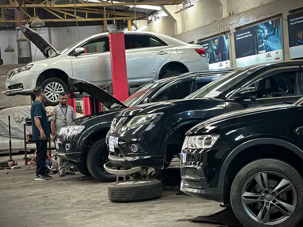 Autobahn Solutions technicians working on a car raised on a lift in the Dhaka workshop