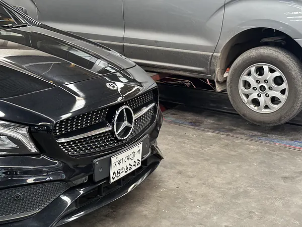 Mercedes-Benz and a microbus inside the Autobahn Solutions workshop, Dhaka