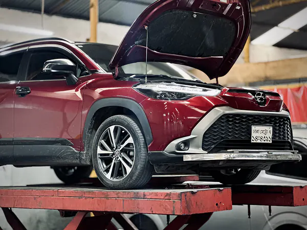 Toyota SUV raised on a lift with the bonnet open at Autobahn Solutions, Dhaka