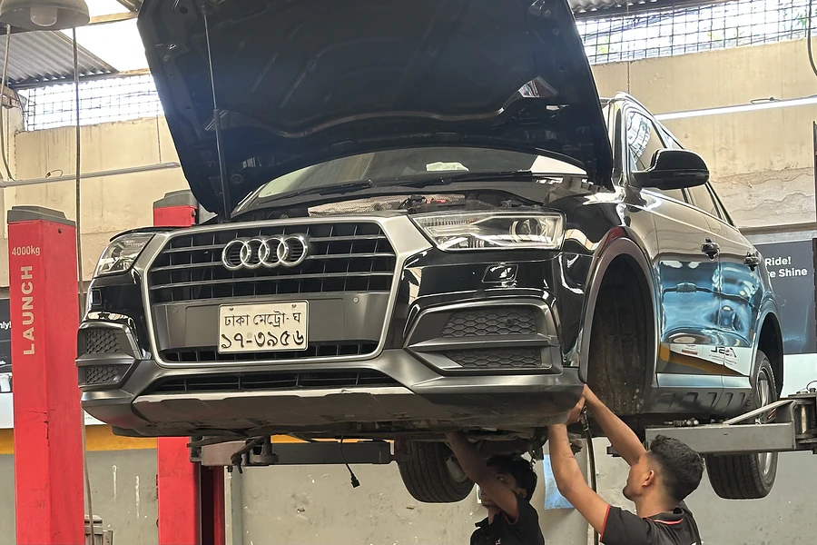 Audi SUV raised on a two-post lift while Autobahn Solutions technicians work underneath
