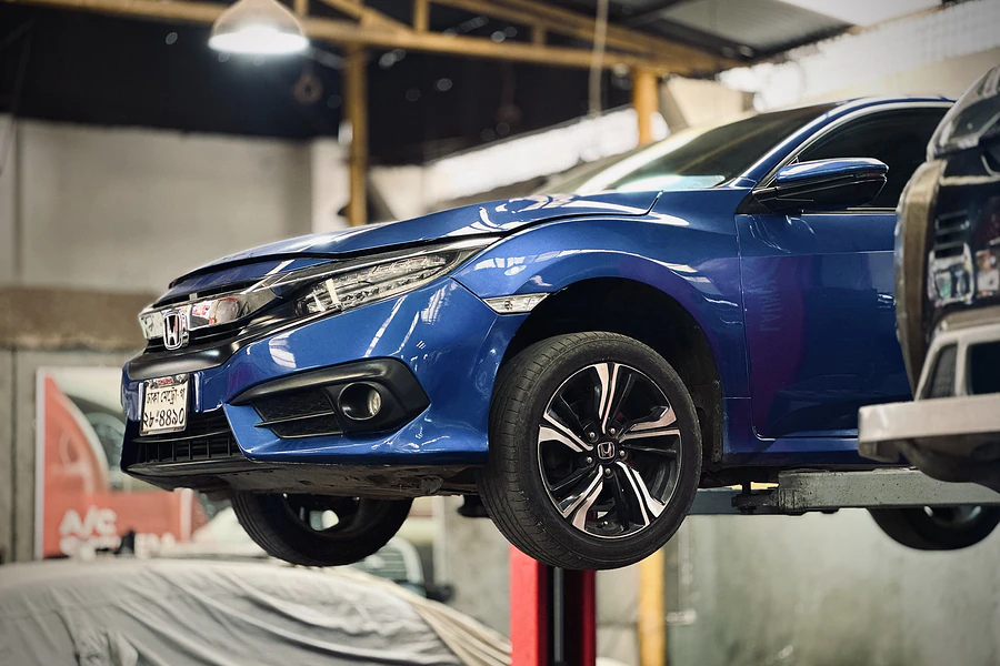 Honda Civic raised on a workshop lift for underbody service