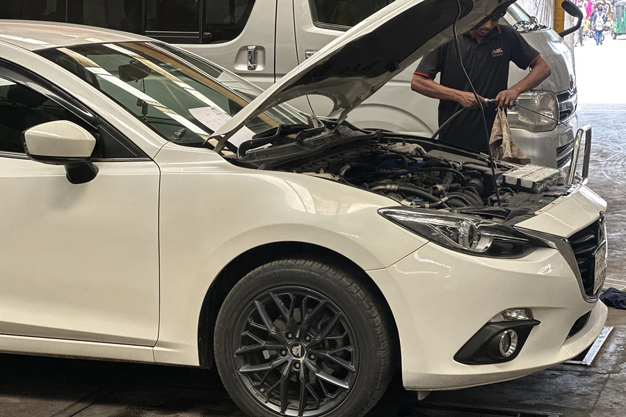 Autobahn Solutions technician working under the bonnet of a Mazda