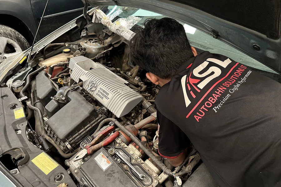Autobahn Solutions technician working on a Toyota hybrid engine bay